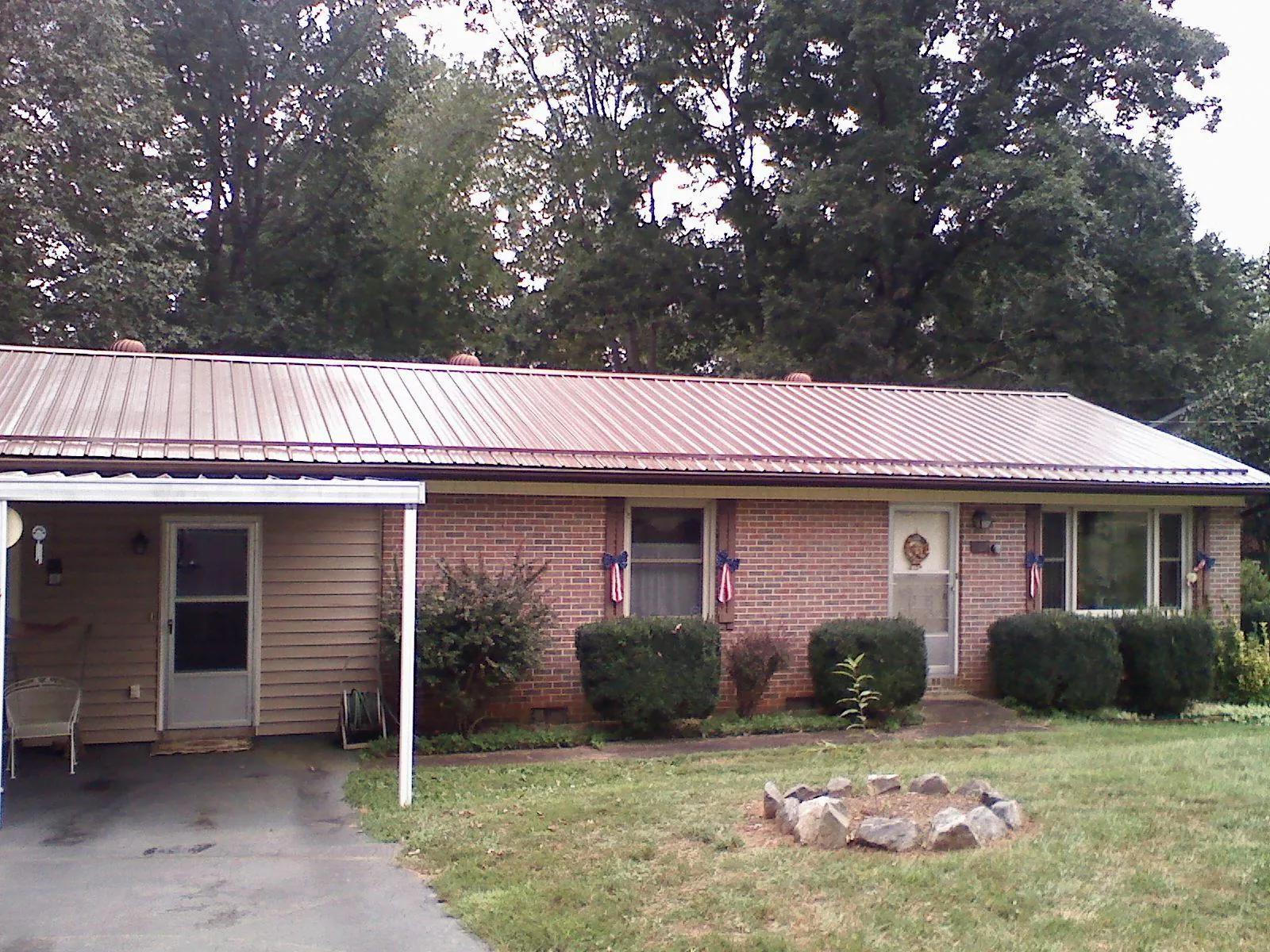 Bronze metal roof and carport on a brick ranch home — Roof Repair work by our crew in Vance